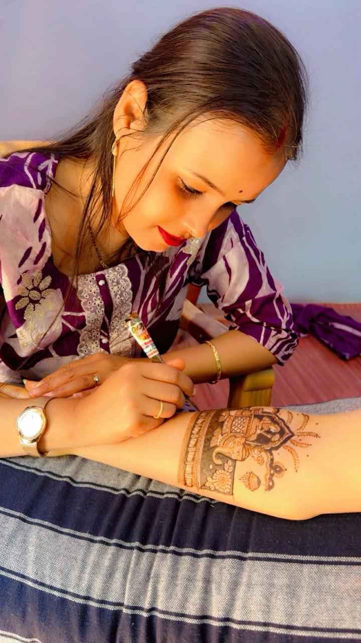 Student applying an elephant mehandi design